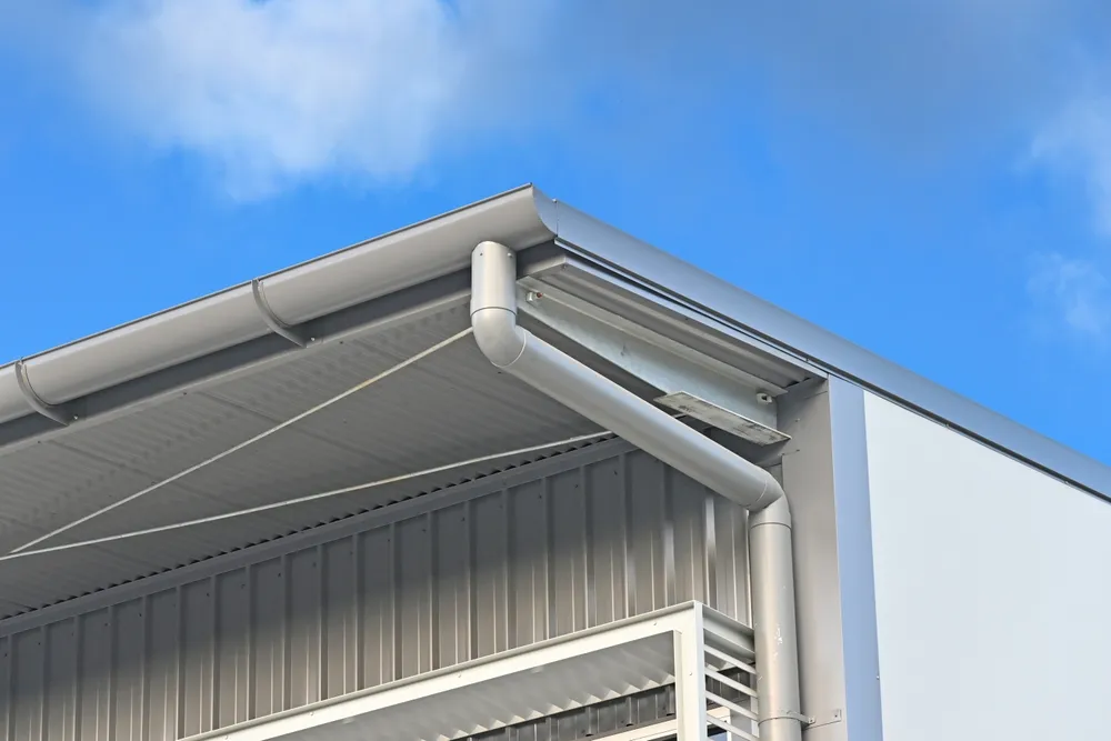 Corner of a building showing half round gutter and downpipe